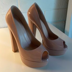 Nude patent leather synthetic material platform heels.